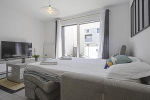1 dormitorio con cama grande y ventana grande en Superb apartment with a beautiful balcony - Anglet - Welkeys, en Anglet