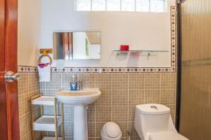 y baño con lavabo, aseo y espejo. en Villas de la Selva, en Manuel Antonio