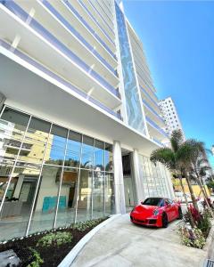 une voiture rouge garée devant un bâtiment dans l'établissement Brickell Hotel apto g 08 Santo Domingo Bella Vista, à Saint-Domingue