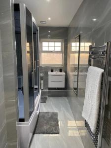 een badkamer met een wastafel, een douche en een wastafel Kor M Hbestosbestos bij 2 Double Bedroom Apartment in Edgware, London in Edgware