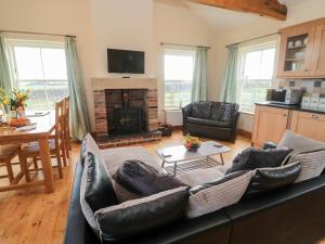a living room with a couch and a fireplace at Bank Top Cottage in Embleton