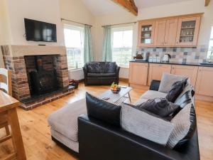 a living room with a couch and a fireplace at Bank Top Cottage in Embleton