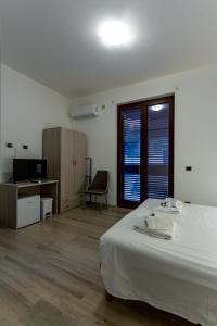 Dormitorio con cama, escritorio y TV en ASTRA B&B, en Milazzo