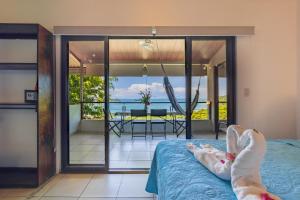a bedroom with a bed and a view of the ocean at Villas de la Selva in Manuel Antonio