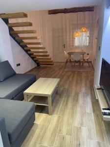 sala de estar con sofá, mesa y escaleras en Precioso loft en Olula del Río, en Olula del Río