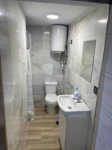 Un baño blanco con inodoro y lavabo. en Precioso loft en Olula del Río, en Olula del Río
