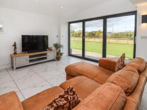 a living room with two couches and a flat screen tv at Phoenix House in Castlemorton
