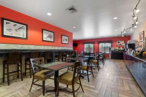 un restaurante con mesas, sillas y paredes rojas en Best Western Plus Suites Greenville, en Greenville