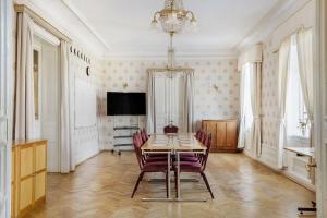 a dining room with a table and chairs and a television at Amals Stadshotell, BW Signature Collection in Åmål