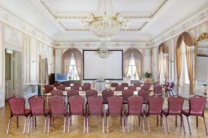 a conference room with a table and chairs and a screen at Amals Stadshotell, Sure Hotel Collection by Best Western in Åmål