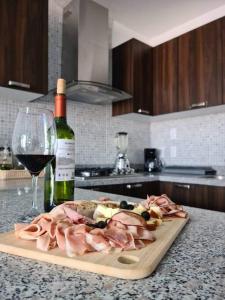 a cutting board with meat and a glass of wine at Departamento en el corazón de Guadalajara in Guadalajara