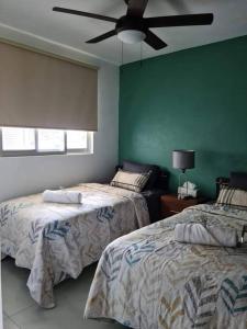 a bedroom with two beds and a ceiling fan at Departamento en el corazón de Guadalajara in Guadalajara