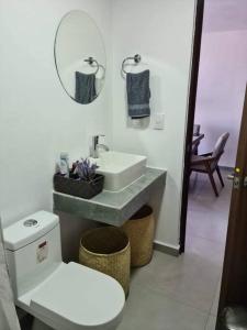 a bathroom with a sink and a toilet and a mirror at Departamento en el corazón de Guadalajara in Guadalajara