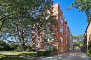 un edificio in mattoni con un albero accanto a una strada di 1BR Relaxing Apartment in Downtown Skokie - Elm 2D a Skokie