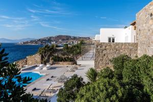a view of a resort with a swimming pool and the ocean at Villa Deloxenia by Ethos Hospitality in Mikonos
