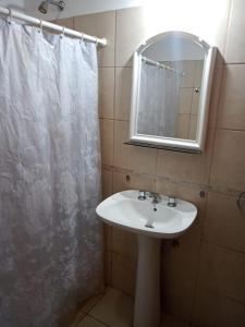 a bathroom with a sink and a shower curtain at Cabaña en quinta la aurora in Mina Clavero