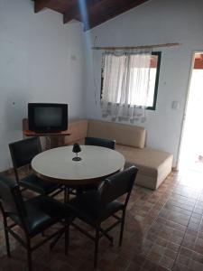 a living room with a table and chairs and a couch at Cabaña en quinta la aurora in Mina Clavero +43 photos