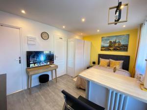 a bedroom with a bed and a desk with a television at Paris Homestay of Happyness in Le Kremlin-Bicêtre