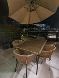 d'une table, de chaises et d'un parasol sur le balcon. dans l'établissement Condominio del faro frente a playa, à Nuevo Vallarta