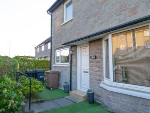 a brick house with a white door and a window at Grace Court in Aberdeen