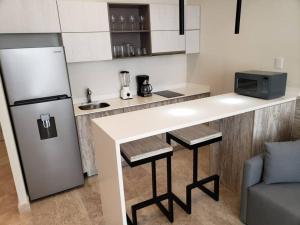 a kitchen with a white counter and a refrigerator at Estudio súper cómodo acogedor y tranquilo in Tulum