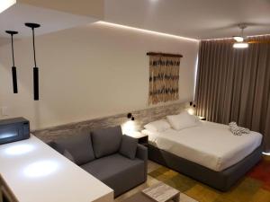 a hotel room with a bed and a couch at Estudio súper cómodo acogedor y tranquilo in Tulum