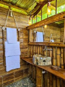 La salle de bains en bois est pourvue d'un lavabo et de serviettes. dans l'établissement Glamping Tambores, 