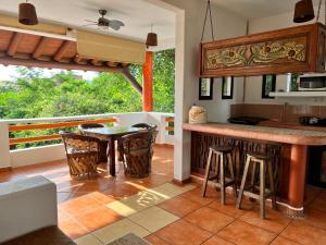 uma cozinha com um balcão e uma mesa com bancos em Villa el Arca em Zihuatanejo