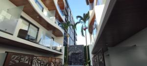 an alley between two buildings with a palm tree at Menesse mitdtown2 , AVE 25TH in Playa del Carmen