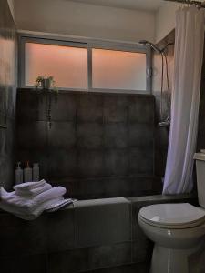 uma casa de banho com uma banheira, um WC e uma janela. em Acogedor departamento totalmente remodelado, tranquilo y centrico em Ciudad Juárez