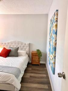 um quarto com uma cama branca e piso em madeira em Acogedor departamento totalmente remodelado, tranquilo y centrico em Ciudad Juárez