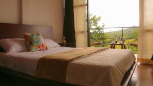 a bedroom with a bed with a view of a balcony at MANIPURA in Guaduas