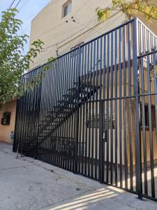 a black metal fence next to a building at Acogedor departamento totalmente remodelado, tranquilo y centrico in Ciudad Juárez