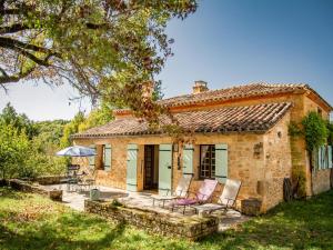 una casa in pietra con due sedie e un tavolo di Maison Sauveterre-la-Lémance a Lapèze