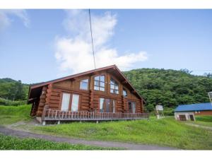 eine Blockhütte auf einem Hügel mit Bäumen in der Unterkunft Haskap - Vacation STAY 40804v in Tōya