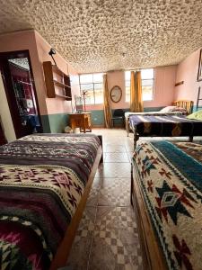 Habitación con 2 camas en una habitación con techo en Hostal Carlos Luis, en Quito