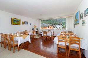 a dining room with tables and chairs and a window at Napolitano Apart Hotel in Baños