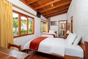 two beds in a room with two windows at Napolitano Apart Hotel in Baños