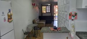 a kitchen and a living room with a counter top at Casa De Praia Maranduba in Ubatuba