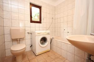 uma casa de banho com um WC, um lavatório e uma máquina de lavar roupa em Apartments with a parking space Opatija - 7904 em Opatija