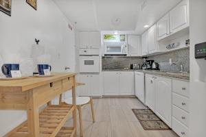 a kitchen with white cabinets and a wooden table at THE TIDES 2bedrooms apt 14th floor WE ARE ON THE BEACH! in Hollywood