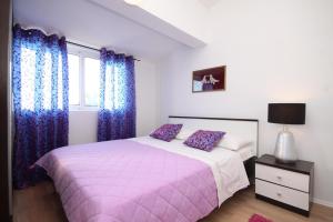 1 dormitorio con cama rosa y cortinas azules en Apartments for families with children Zdrelac, Pasman - 8424 en Ždrelac