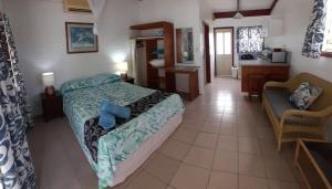 a bedroom with a bed and a chair in a room at Reefcomber Sunset Beach in Rarotonga