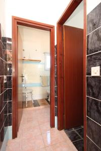ein Bad mit einer Tür, die zu einem WC führt in der Unterkunft Apartments with a parking space Tkon, Pasman - 8411 in Tkon