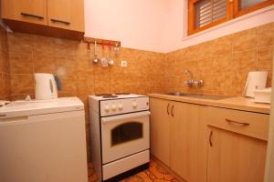 a small kitchen with a stove and a sink at Apartments with a parking space Mlini, Dubrovnik - 9018 in Mlini