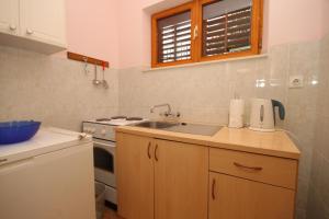 a kitchen with a sink and a stove at Apartments with a parking space Mlini, Dubrovnik - 9018 in Mlini