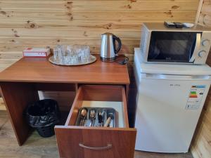 une table avec un four micro-ondes et un réfrigérateur avec un tiroir dans l'établissement Шафран, à Krasnaya Slobodka