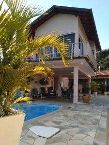 a villa with a swimming pool and a house at CANTINHO DA PAZ! in Águas de São Pedro