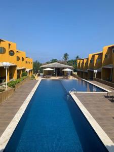 uma grande piscina num resort com edifícios em Condomínio Imbassai Summer Flat em Imbassaí