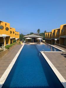 - une piscine d'eau bleue dans un complexe dans l'établissement Condomínio Imbassai Summer Flat, à Imbassaí